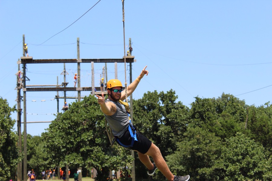 Camp Cowboy student on the high ropes course/ zipline